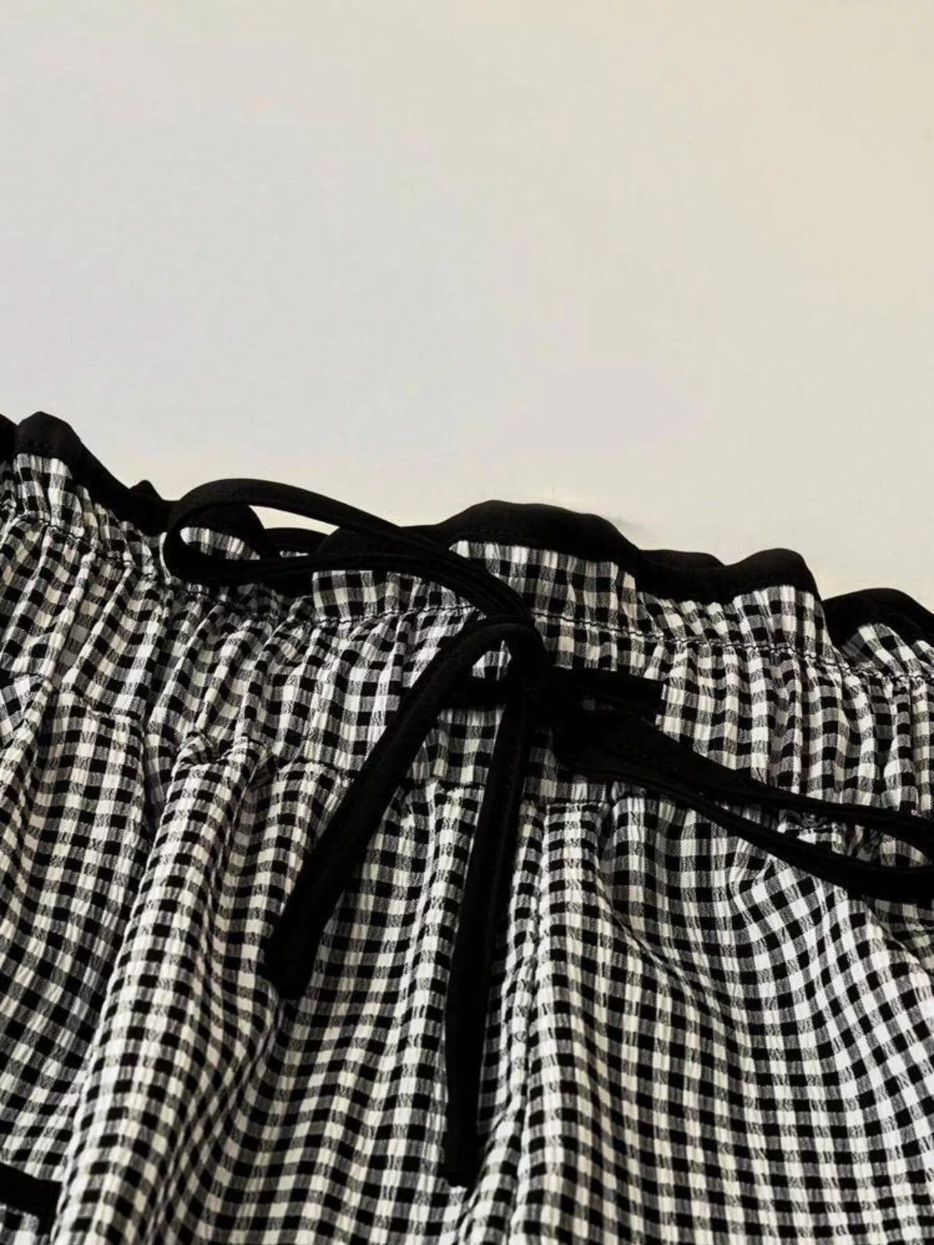 Black and white checkered fabric with a drawstring on a plain background