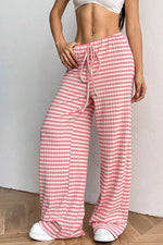 Person wearing pink and white striped pants on a plain background