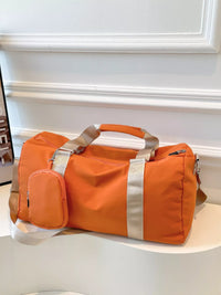 Orange duffel bag with a smaller orange pouch on a white surface.