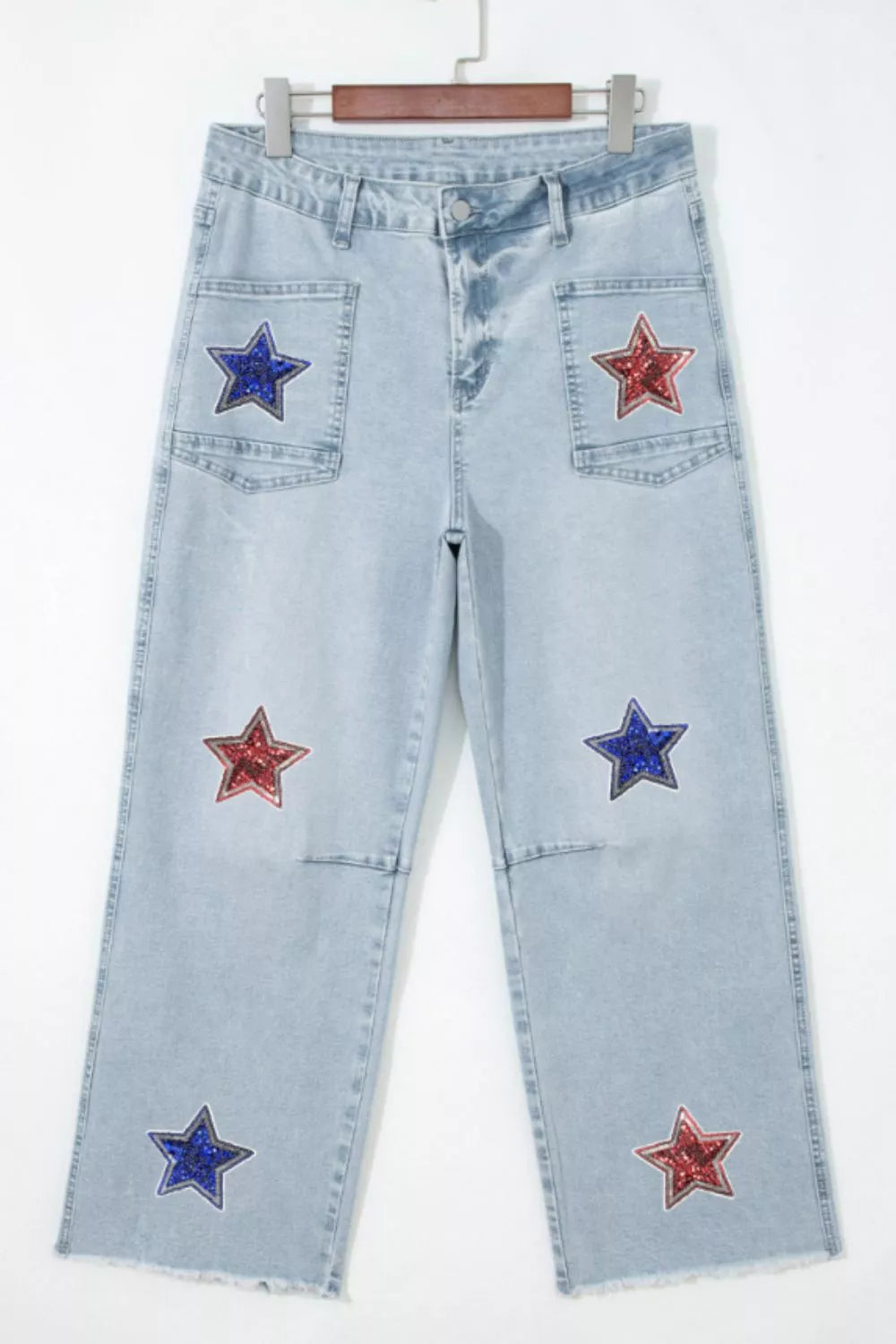 Light blue jeans with star patches on a white background