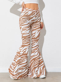 Zebra print flared pants worn by a person on a white background