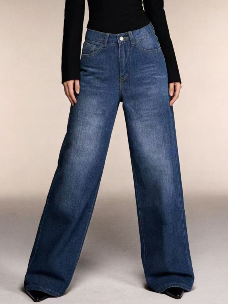 Blue jeans worn by a person on a plain background