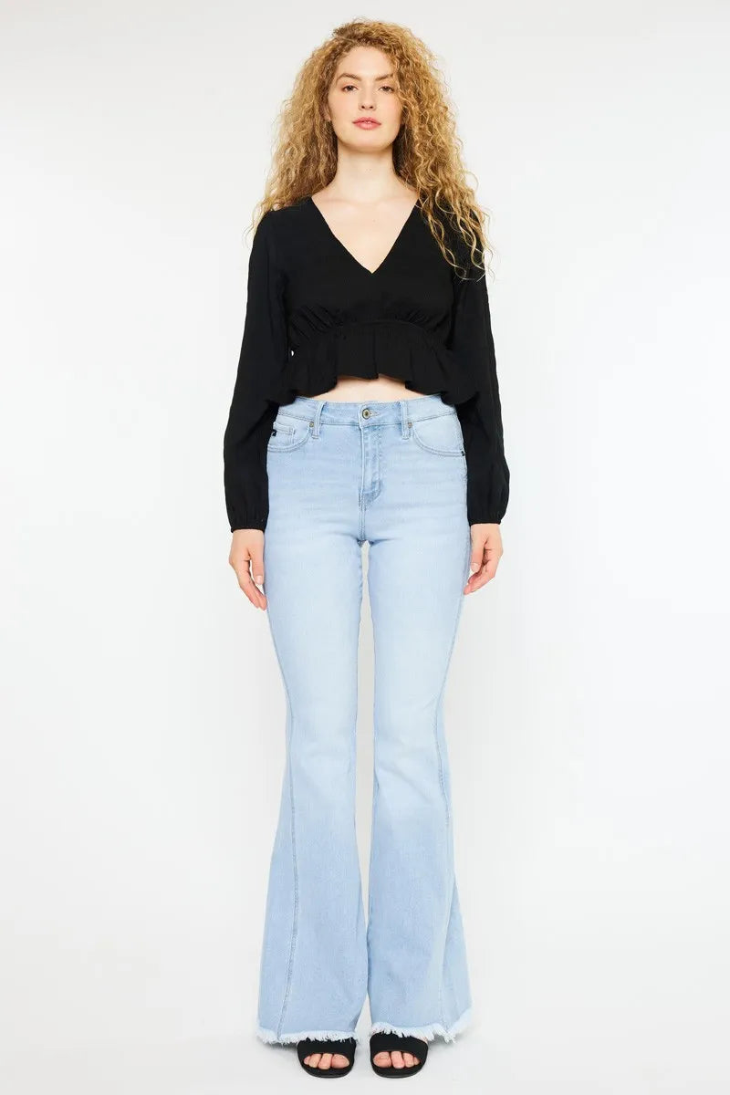 Woman wearing a black top and light blue jeans on a white background