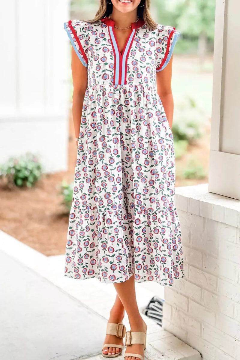 Woman wearing a floral dress with colorful trim in an outdoor setting