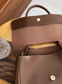 Brown leather backpack on a wooden surface