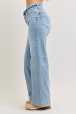 Light blue jeans worn by a person on a plain background