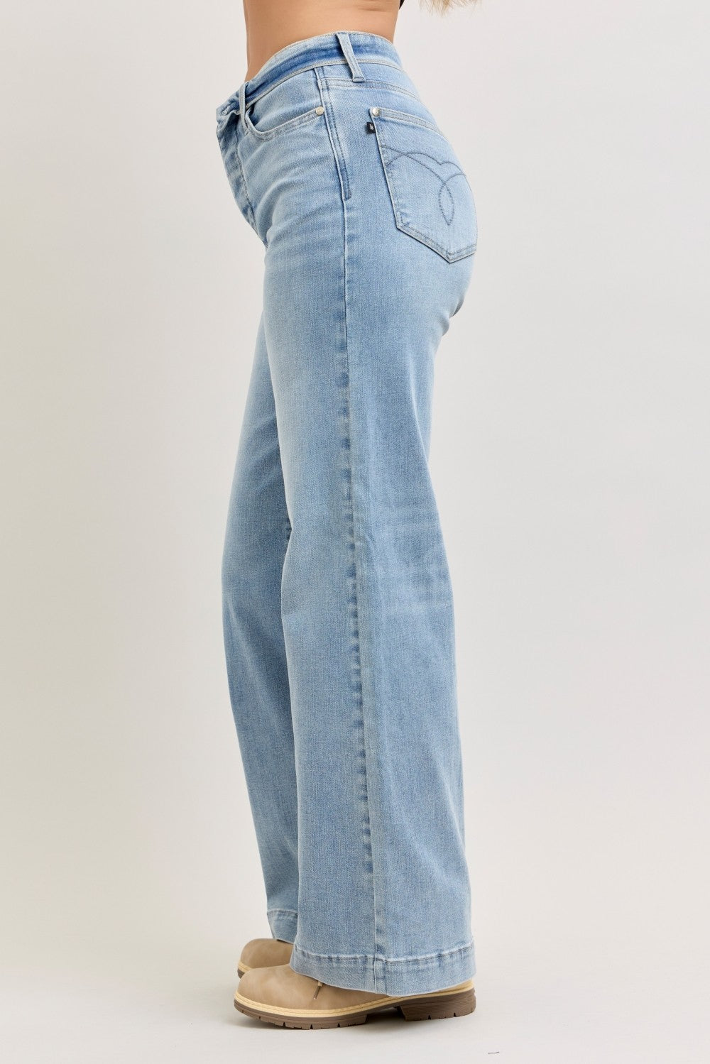 Light blue jeans worn by a person on a plain background