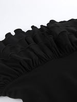 Close-up of a black fitted sheet with ruffled edge on a white background