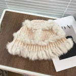 Pink knitted hat with white fur trim on a wooden surface
