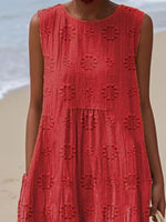 Red dress with a textured pattern worn by a person on a beach.