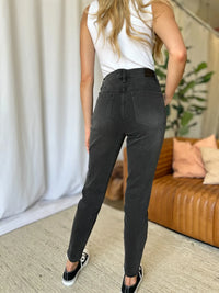 Person wearing black pants and a white top in a living room setting