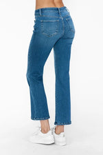 Blue jeans worn by a person on a white background