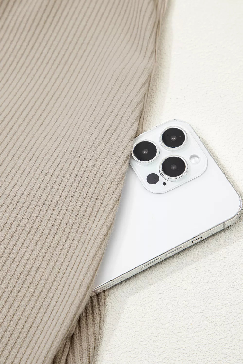 Close-up of a smartphone with a beige textured fabric background