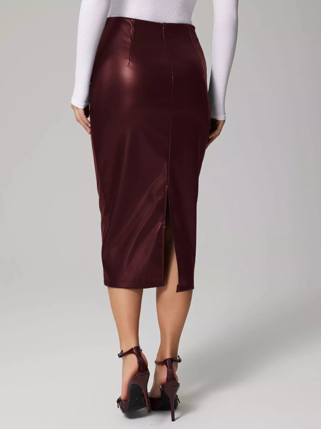 Person wearing a burgundy satin skirt on a plain background