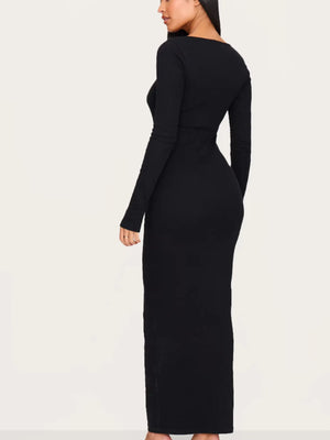 Black long-sleeve dress worn by a person on a white background