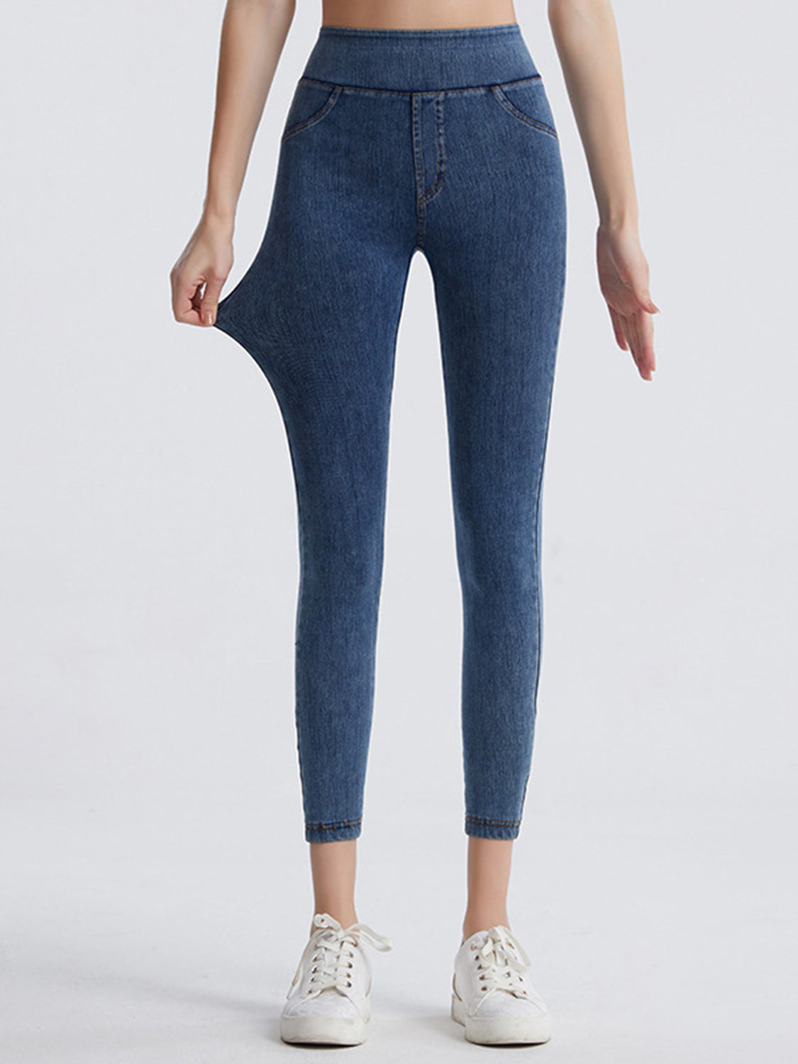 Blue jeans worn by a person on a white background