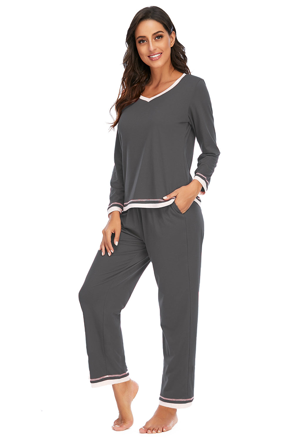 Woman wearing gray pajama set with white trim on a white background