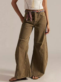 Brown wide-leg jeans worn by a person on a plain background