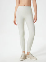 Person wearing light gray leggings on a white background