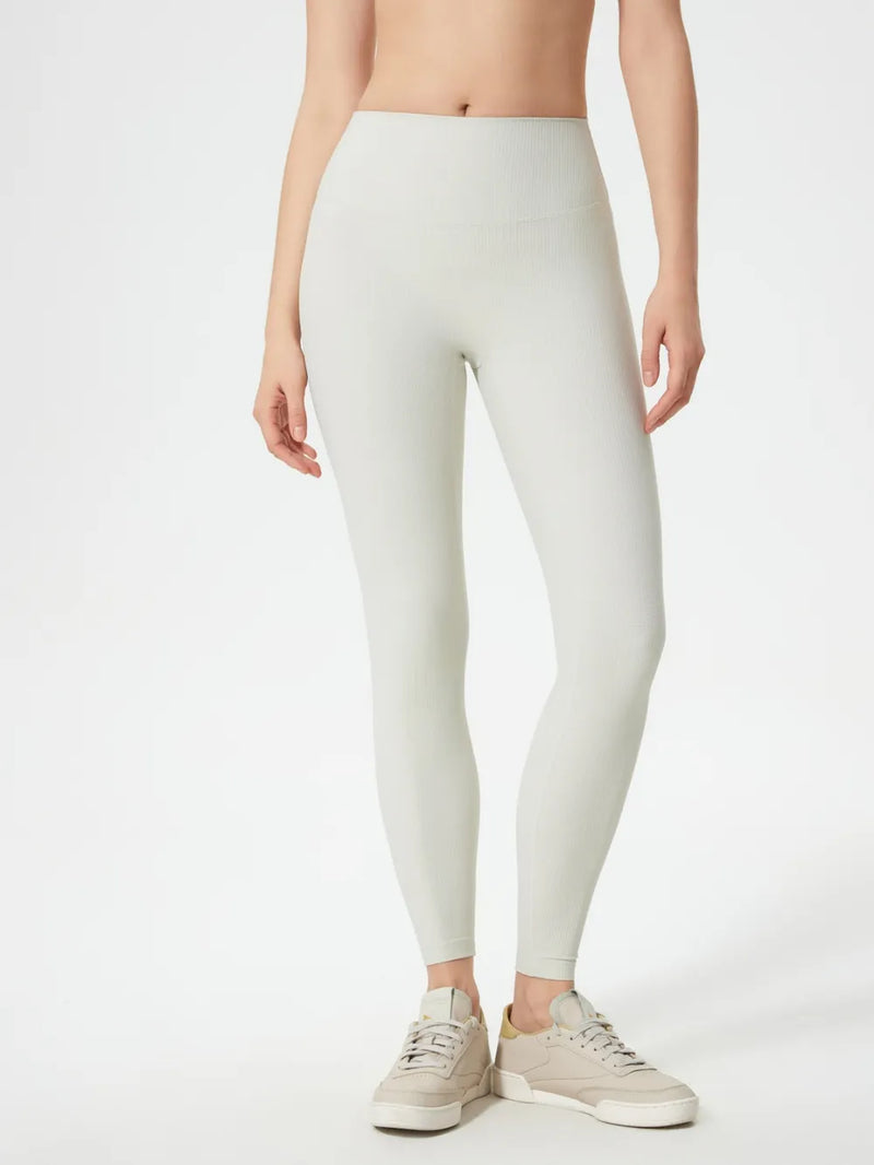 Person wearing light gray leggings on a white background
