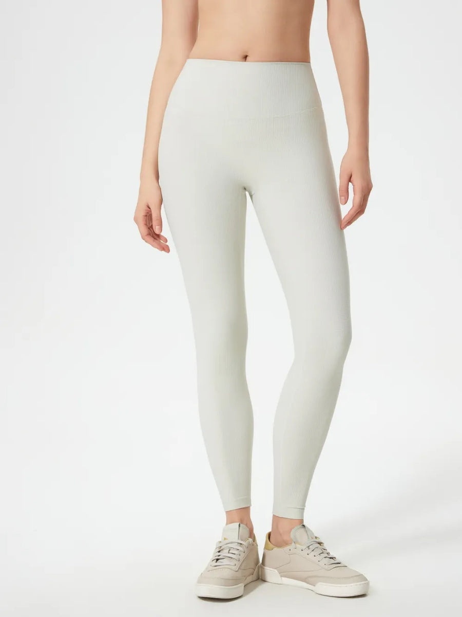 Person wearing light gray leggings on a white background