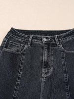 Close-up of black denim jeans on a beige background