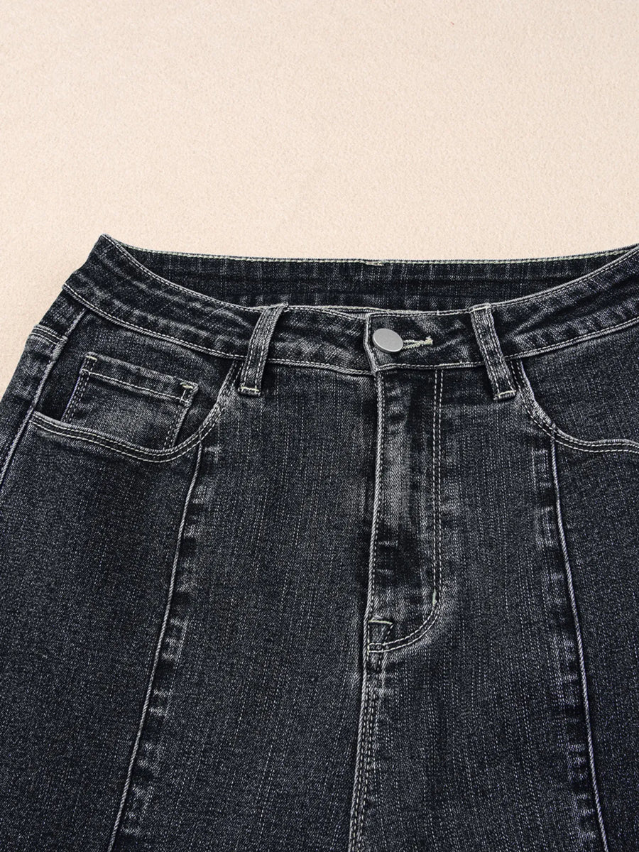 Close-up of black denim jeans on a beige background
