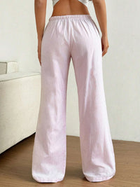 Person wearing light pink corduroy pants in a minimal indoor setting