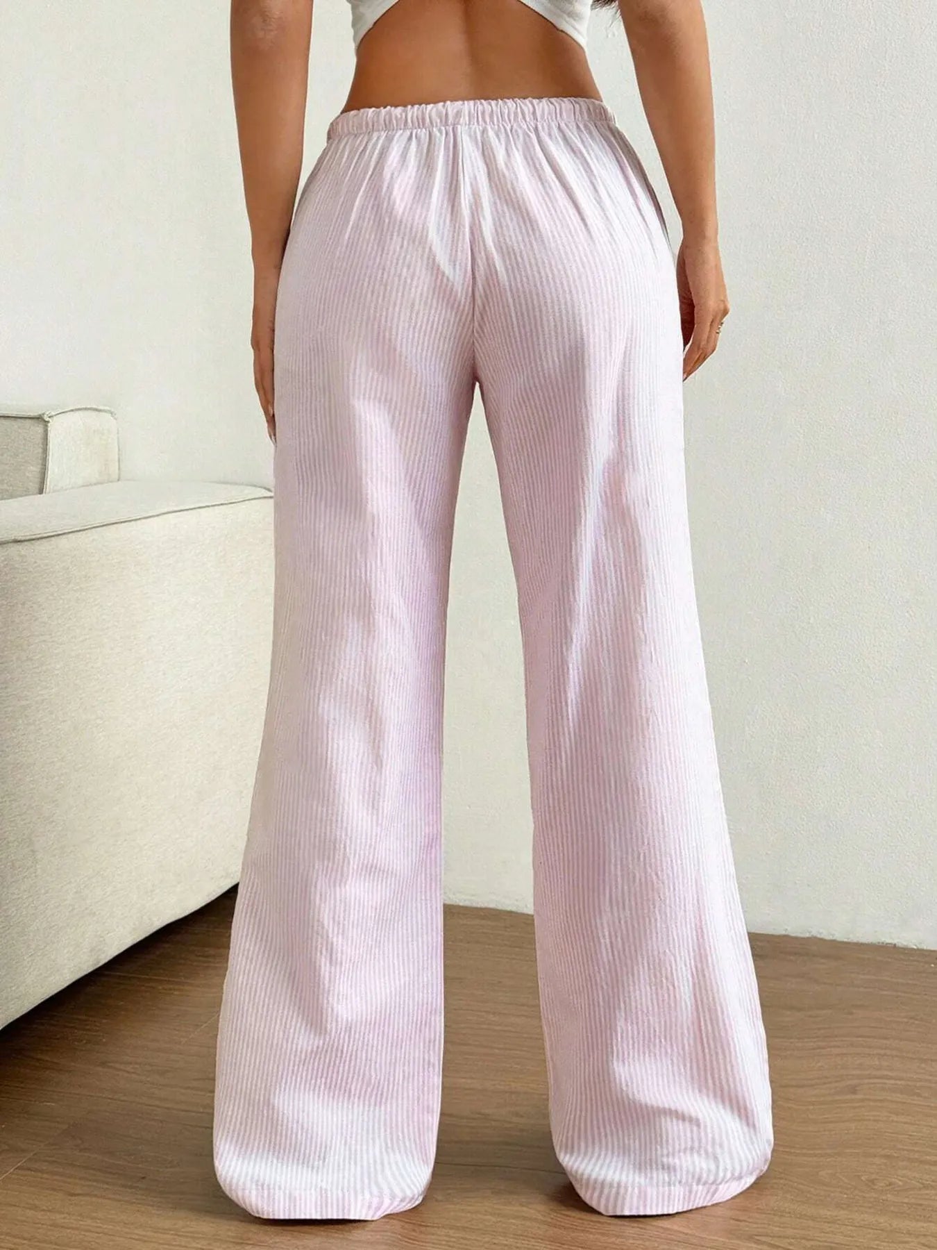 Person wearing light pink corduroy pants in a minimal indoor setting