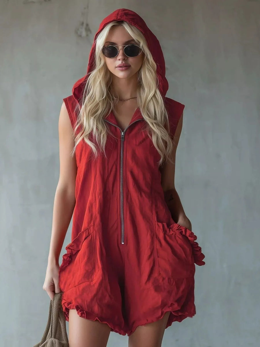 Woman wearing a red hooded dress against a plain background
