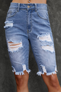 Ripped blue denim shorts on a dark gray background