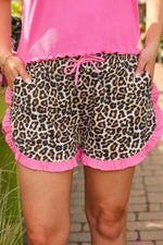 Leopard print shorts with pink trim worn by a person.
