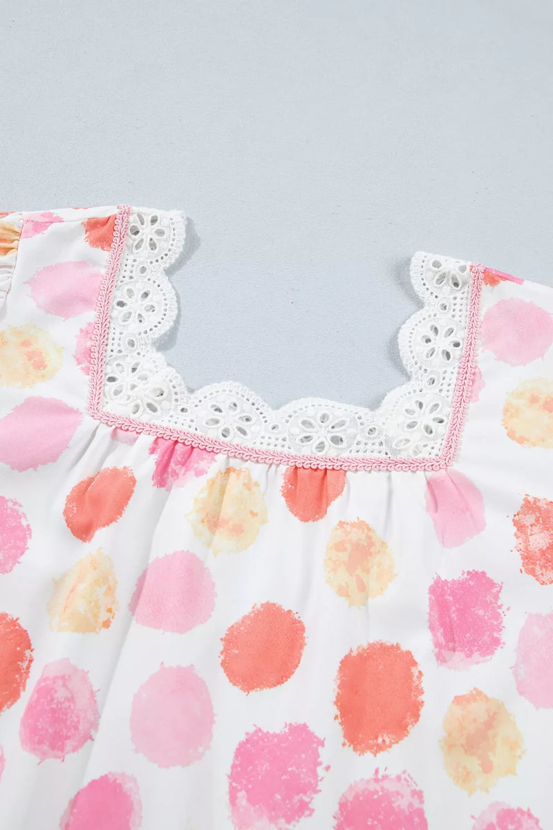 Children's dress with colorful polka dot pattern and lace trim on a light gray background