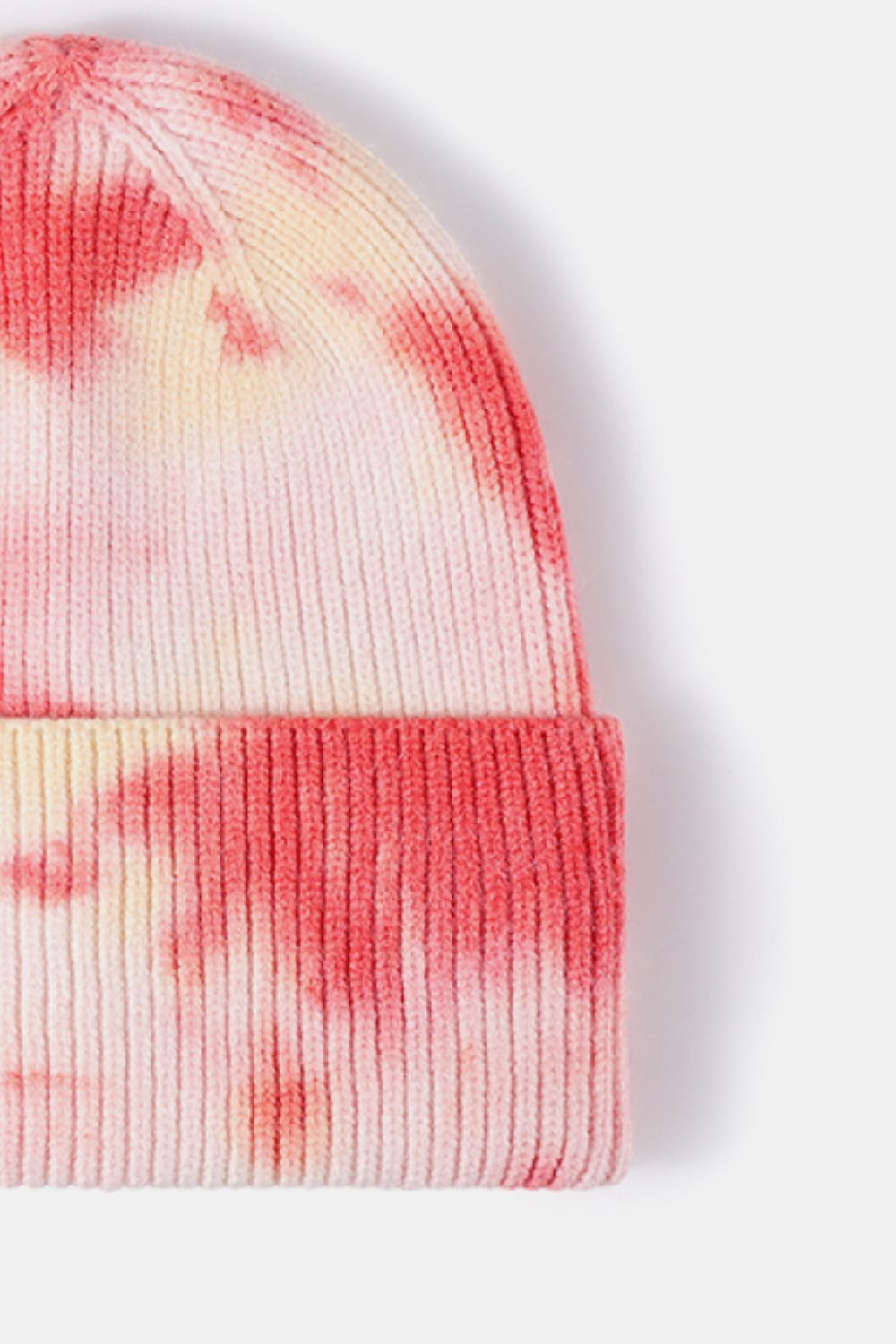 Tie-dye beanie with pink and yellow patterns on a white background