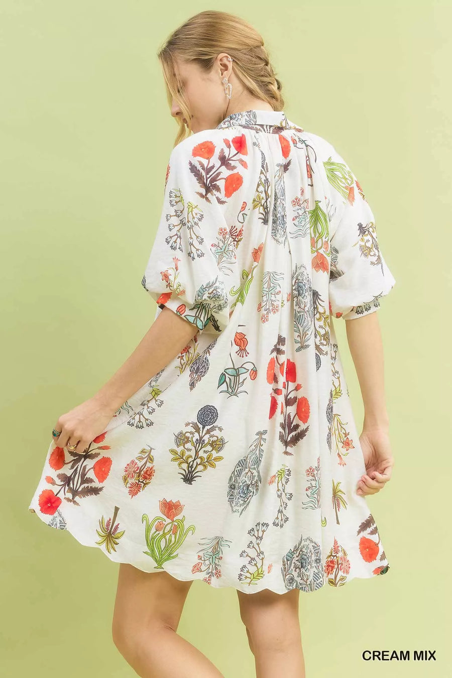 Woman wearing a floral kimono-style dress against a light green background