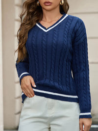 Woman wearing a blue cable knit sweater with white trim