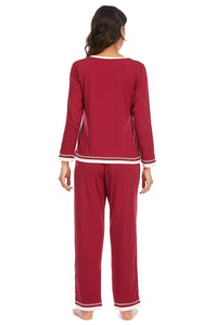 Red pajama set with white trim worn by a person on a white background