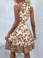 Woman wearing a floral dress against a light gray wall.