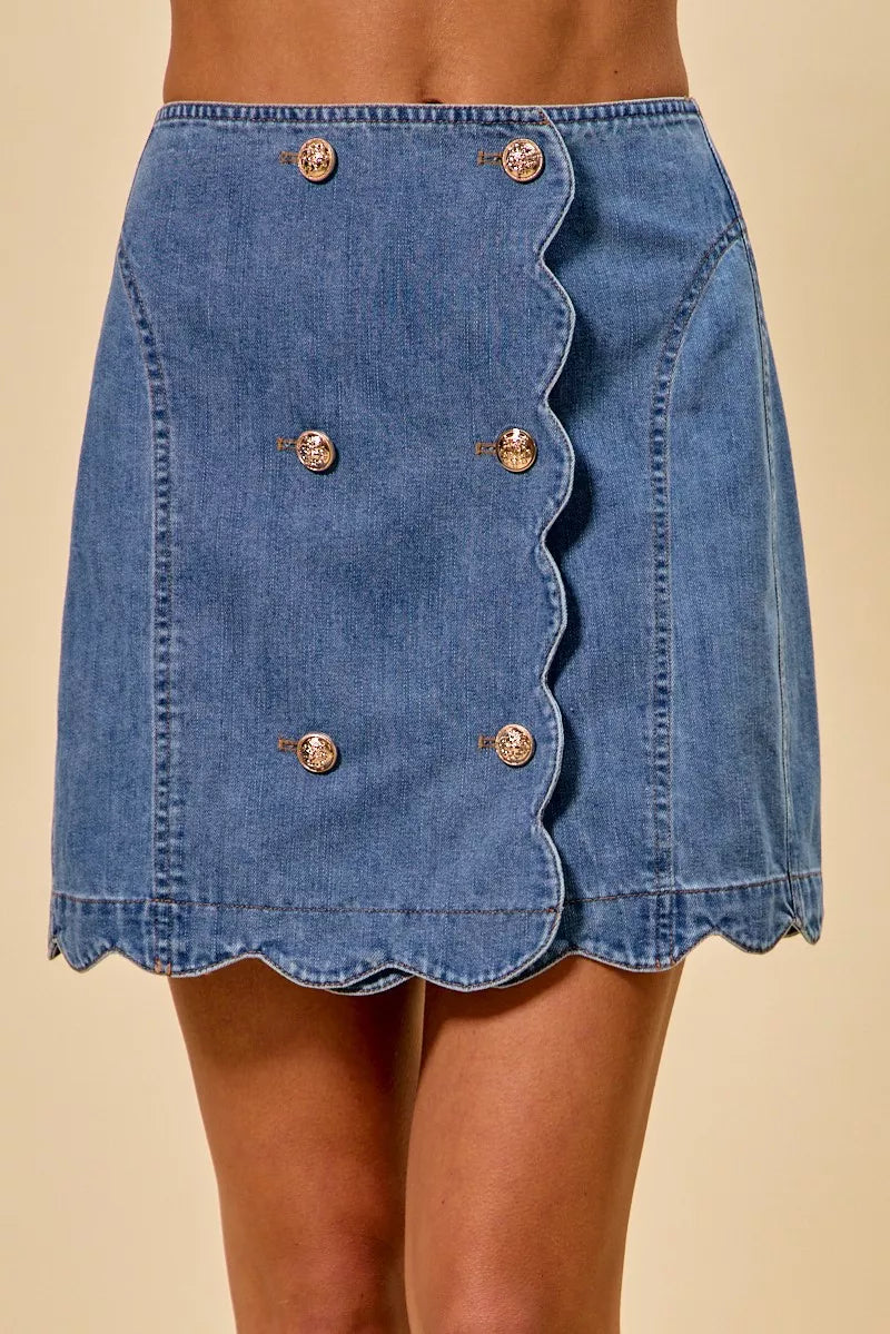 Blue denim skirt with button details on a beige background