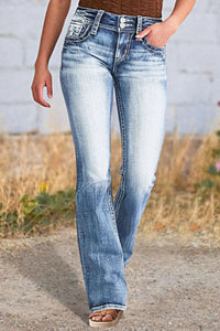 Person wearing blue jeans walking on a dirt path with a blurred natural background