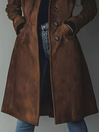 Brown leather coat worn by a person on a plain background