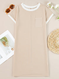 Beige ribbed dress on a light brown surface with sunglasses and flowers.