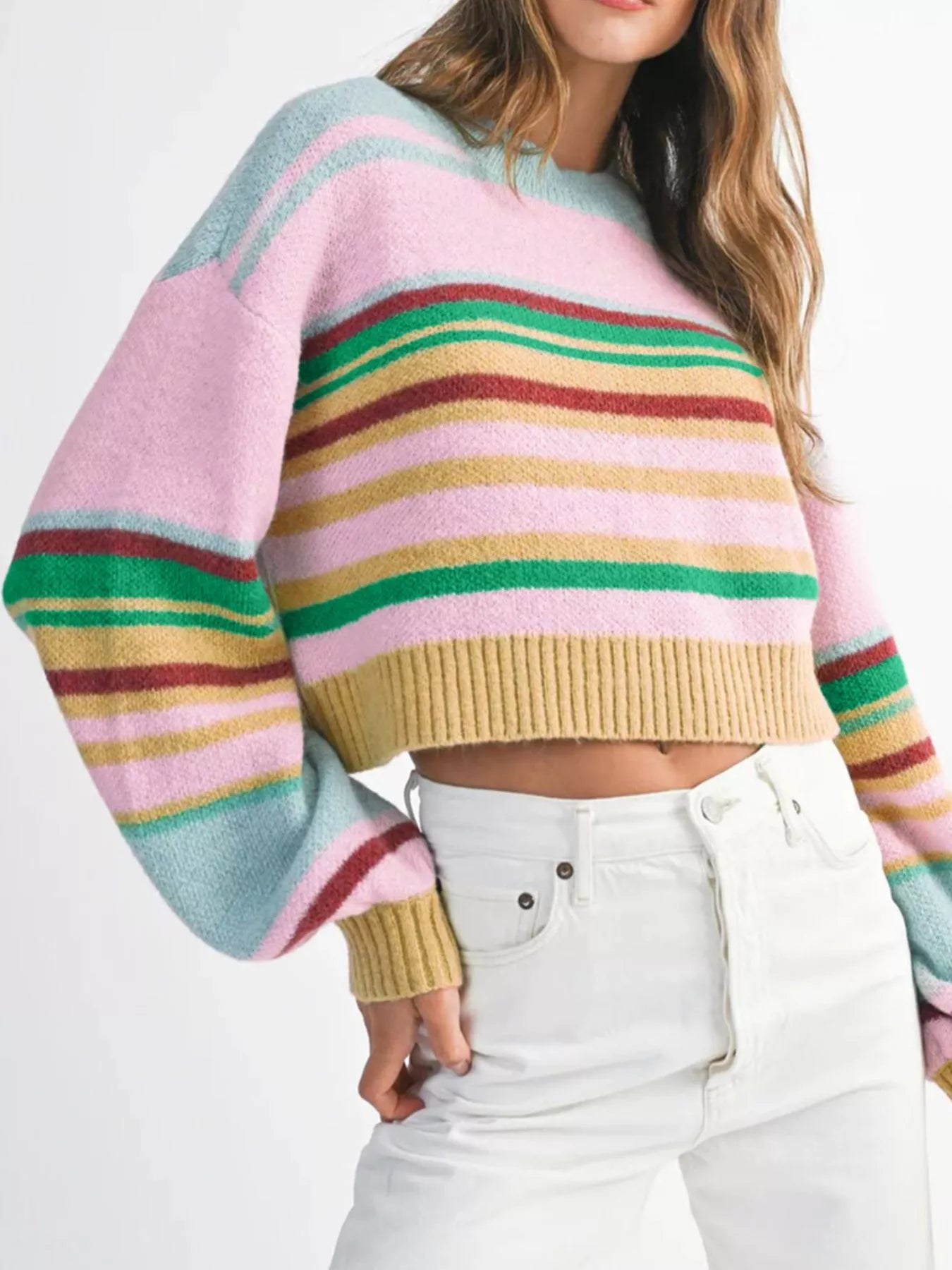 Multicolored striped sweater worn by a person on a white background