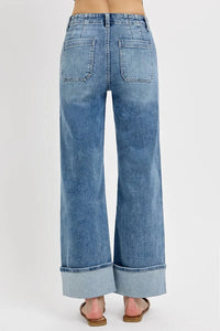 Blue jeans with a rolled hem on a white background