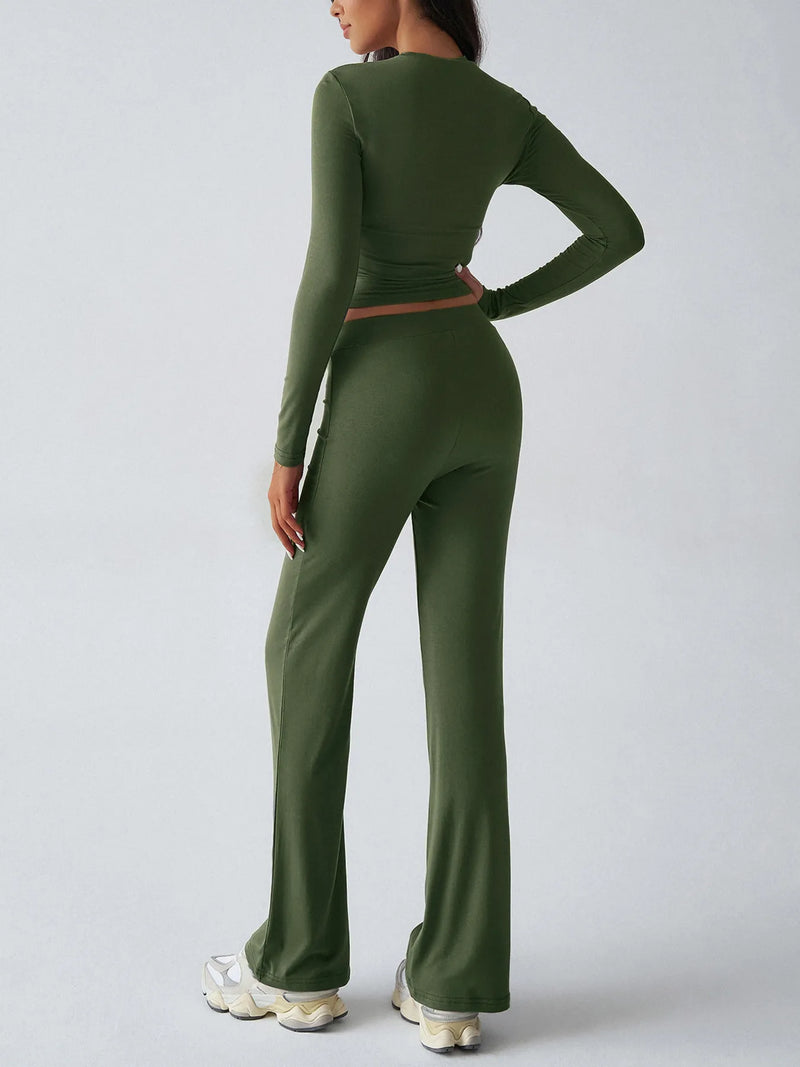 Person wearing a green long-sleeve top and pants set on a light gray background