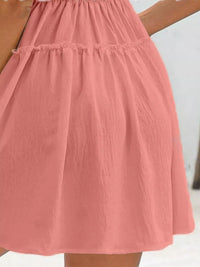 Pink skirt on a wooden hanger against a white background