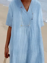 Person wearing a light blue dress on a beach