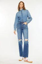 Woman wearing a denim jacket and jeans on a white background