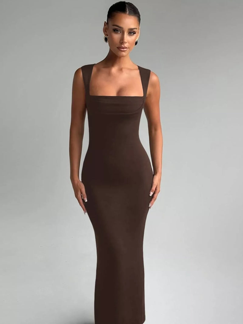 Woman wearing a brown evening gown against a gray background
