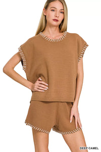 Woman wearing a brown sleeveless top and shorts with decorative trim on a white background